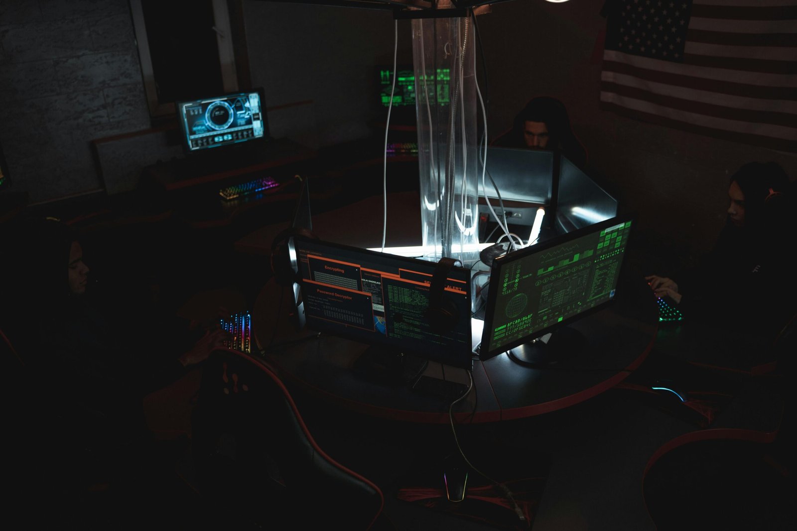 Team of cybersecurity experts collaboratively working on data protection in a dimly lit room filled with computers.